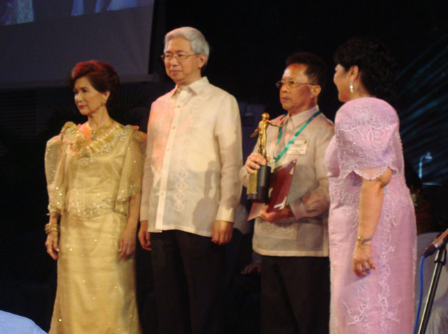 Dr. Faylon (third from left) holds his trophy which represents his significant achievements in S&T, specifically in the agriculture, aquatic and natural resources sectors. UP President Alfredo Pascual (second from left) leads the conferment of the award.