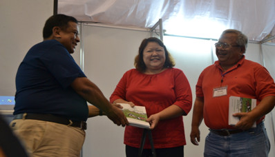 Other partners. Marissa Abad (center) of GASPAT receives a copy.