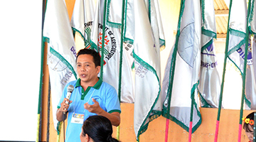 Cyril Tom Ranara of the Davao del Norte State College explaining the Pangtawid Project for the Rehabilitation of Davao Oriental and Compostela Valley to attendees of the Seaweed Fiesta. 