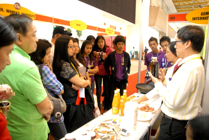 PCARRD Applied Communication Division Assistant Director Cesar Frias (rightmost) discussing the different uses of pili oil while Magsasaka Siyentista Rebecca Tubongbanua (2nd from the right) demonstrates how to cook Pasta in Mango sauce sautéed in pili oil.